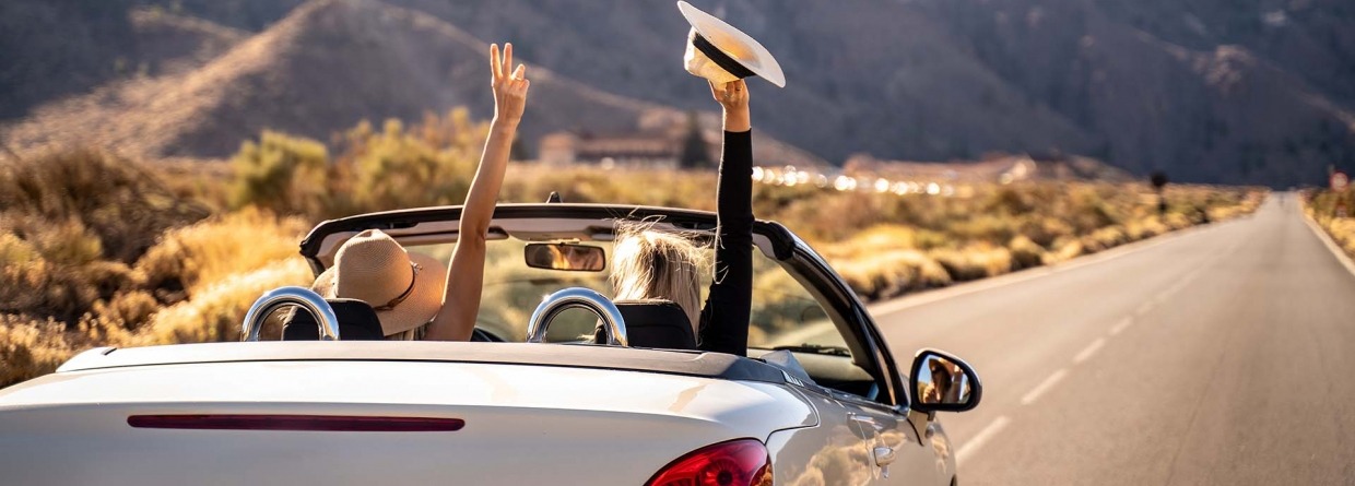 Autorondreis; twee vrouwen in een cabrio rijden door de bergen
